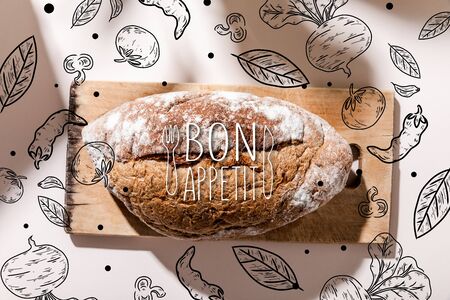 top view of bread on cutting board on grey table with bon appetit lettering and vegetables drawing