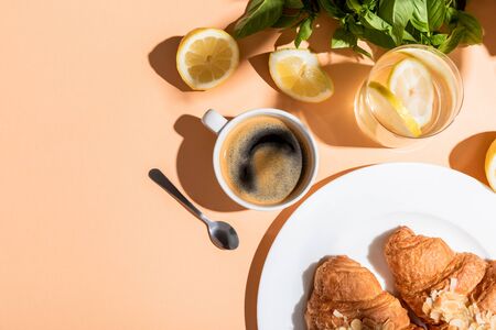 top view of coffee cup and croissants for breakfast on beige tableの写真素材