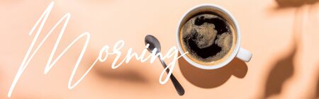 top view of coffee cup and teaspoon on beige with morning lettering, website headerの写真素材