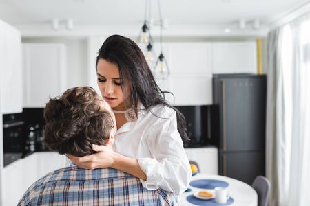 Beautiful woman touching neck of boyfriend at home