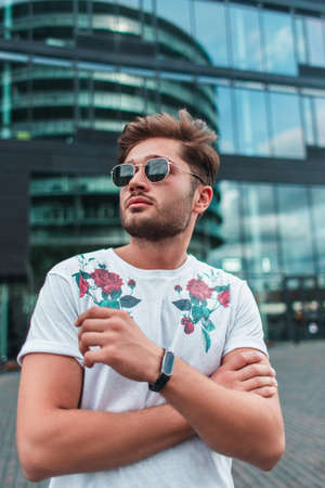 Young man in sunglasses looking away on urban street