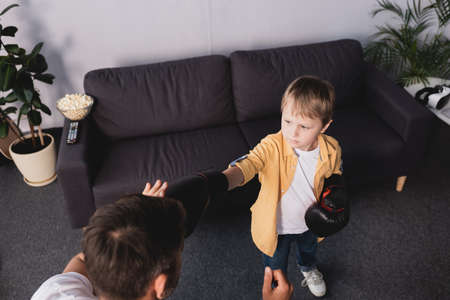 high angle view of boy in boxing gloves fighting with fatherの写真素材