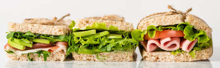 fresh green sandwiches with avocado and meat on white surface, panoramic shotの写真素材