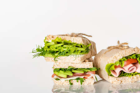 fresh green sandwiches with avocado and meat on white surfaceの写真素材
