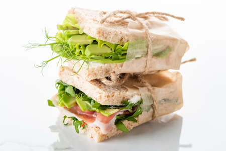 fresh green sandwiches with avocado and jamon on marble white surfaceの写真素材