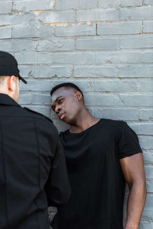 selective focus of worried african american man looking at policeman, racism conceptの写真素材