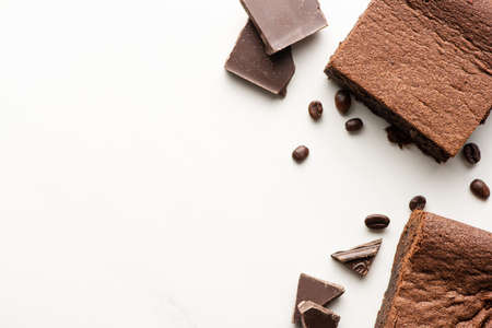 top view of delicious brownie pieces with coffee beans and chocolate on white backgroundの写真素材