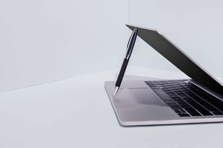 pen in modern laptop on white background
