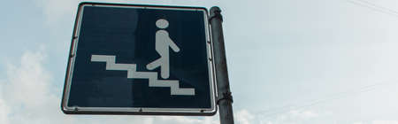Panoramic crop of stairs sign with cloudy sky at background