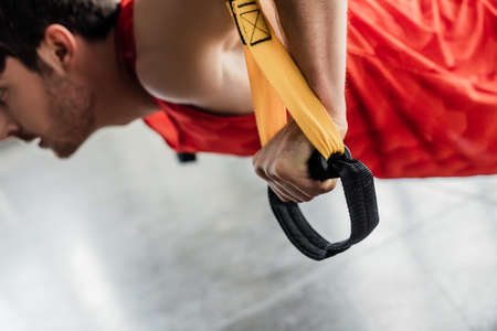 cropped view of sportive man working out with elastics in gymの写真素材