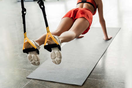 cropped view of woman in sportswear doing plank while exercising with resistance bandsの写真素材