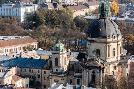 LVIV, UKRAINE - OCTOBER 23, 2019: aerial view of dominican church with latin lettering, surrounded by green treesのeditorial素材