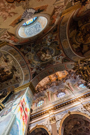 LVIV, UKRAINE - OCTOBER 23, 2019: bottom view of arch and ceiling with paintings in carmelite church