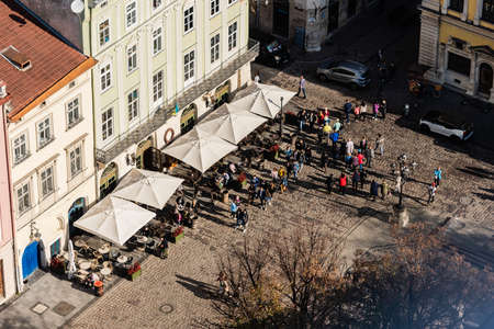 LVIV, UKRAINE - OCTOBER 23, 2019: aerial view of people walking near street cafe on market squareのeditorial素材