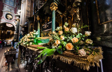 LVIV, UKRAINE - OCTOBER 23, 2019: altar of carmelite church decorated with natural rosesのeditorial素材