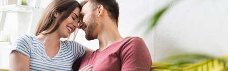 smiling beautiful young couple hugging at home, panoramic orientationの写真素材