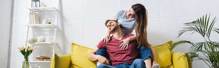 happy beautiful young couple hugging at home, panoramic orientation