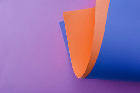 orange and blue paper on violet backgroundの写真素材