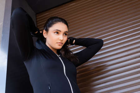 beautiful young woman in sportswear standing outside