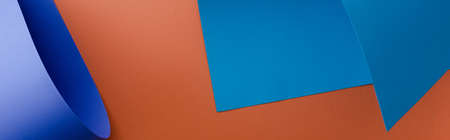 blue colorful paper on orange background, panoramic shotの写真素材