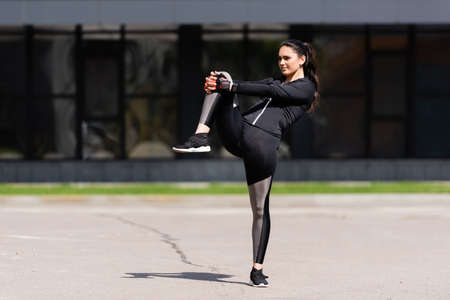 attractive young sportswoman working out on asphalt