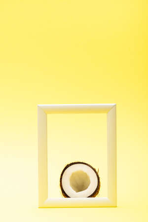 delicious sweet coconut half in square frame on yellow backgroundの写真素材