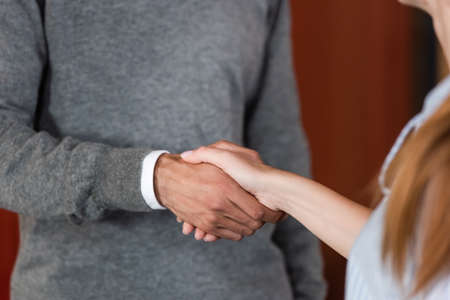 cropped view of businessman and businesswoman shaking hands