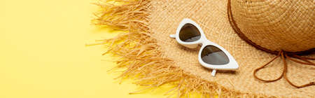 straw hat and stylish suglasses on yellow background, panoramic shotの写真素材