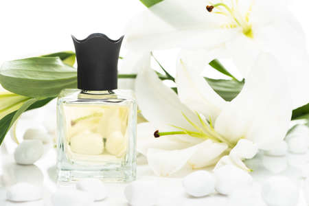 home perfume in bottle near spa stones and lilies on white background