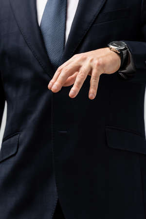 cropped view of businessman in suit manipulating with hand isolated on gray