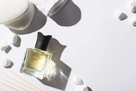 top view of aroma sticks with perfume in bottle near spa stones and towel on white backgroundの写真素材