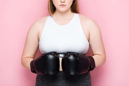 cropped view of size plus girl in white top and boxing gloves on pinkの写真素材
