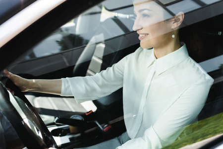Selective focus of smiling businesswoman driving carの写真素材