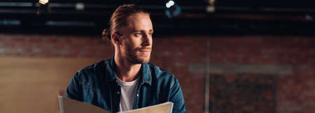 panoramic shot of handsome businessman looking away in modern office