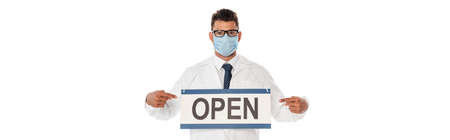 Panoramic crop of doctor in medical mask pointing with fingers at signboard with open lettering...