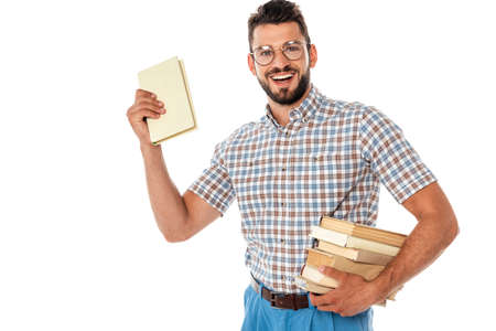 Cheerful nerd in eyeglasses holding books isolated on white