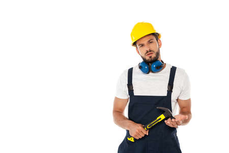 Handsome workman in uniform and hardhat holding hammer and looking at camera isolated on white