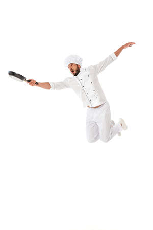 Excited chef holding frying pan while jumping isolated on whiteの写真素材