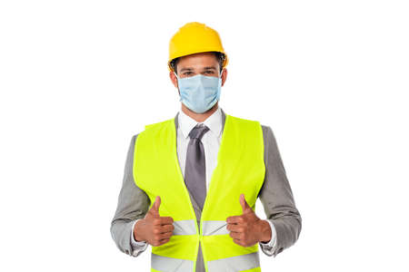 Engineer in hardhat and medical mask showing thumbs up isolated on whiteの写真素材