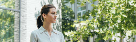 panoramic crop of attractive and young businesswoman outsideの写真素材