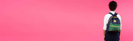 back view of african american schoolgirl with backpack isolated on pink, panoramic shotの写真素材