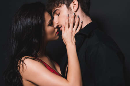 sexy couple with closed eyes kissing on blackの写真素材