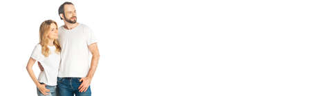cheerful adult couple in white t-shirts embracing isolated on white, panoramic shotの写真素材
