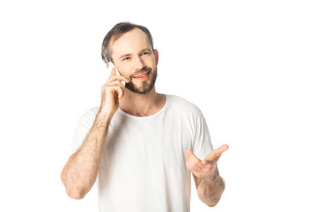 smiling man talking on smartphone and gesturing isolated on white