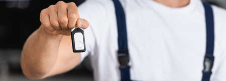 panoramic orientation of mechanic holding car keyの写真素材