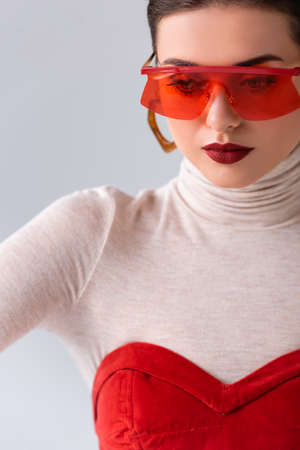 beautiful, stylish girl in red sunglasses posing isolated on grayの写真素材
