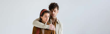 horizontal image of handsome man embracing stylish woman isolated on grayの写真素材