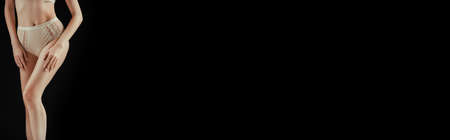 Panoramic crop of young woman in beige panties isolated on black