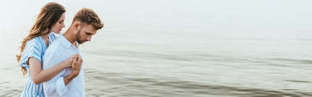 website header of attractive woman hugging handsome boyfriend near riverの写真素材