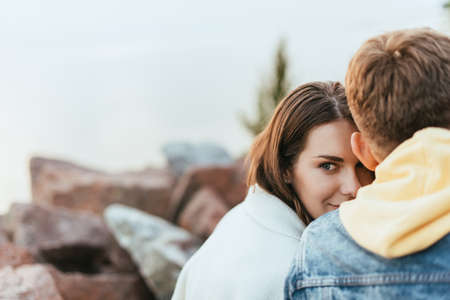 selective focus of happy girl looking away near boyfriend
